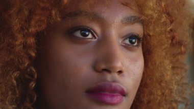 Kapatın. Kıvırcık saç stili ve pembe rujlu kendinden emin Afrikalı Amerikalı siyahi kadın.
