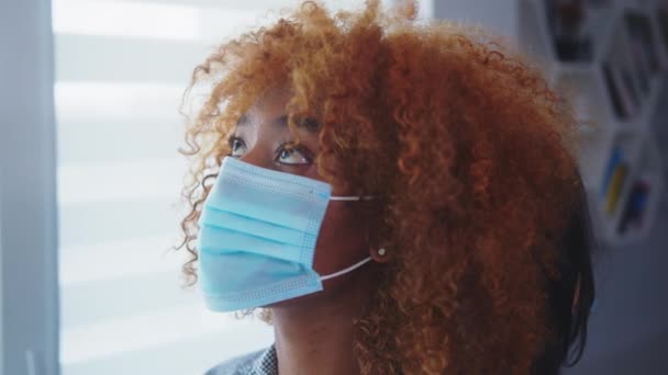 Närbild. Afrikanska amerikanska och asiatiska kvinnor med medicinsk mask som står bakifrån framför fönstret. Multiracial vänskap, bindning under coronavirus — Stockvideo