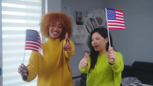 Çok ırklı dostluk ve eşitlik. Afro-Amerikalı ve Asyalı kadın ABD bayrakları taşıyor. Öğrenci değişim programı — Stok video