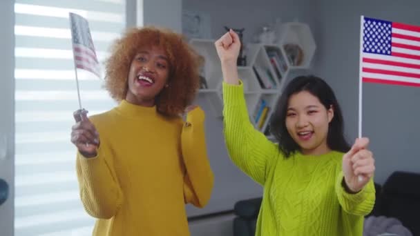 Amizade multirracial, trabalho e programa de viagens. Africano americano e asiático mulher acenando EUA bandeiras — Vídeo de Stock