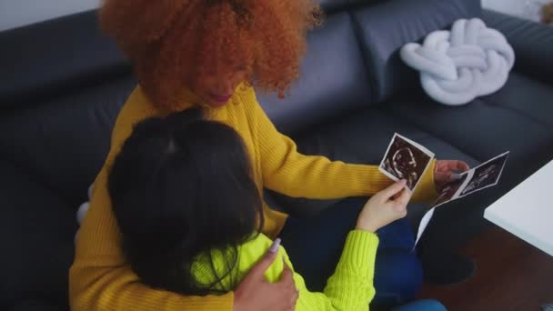Lesbičky čekající na miminko objímající a dívající se na ultrazvuk. — Stock video