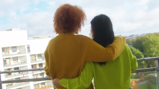 Couple de jeunes femmes interraciales, meilleurs amis ou couple lesbien, buvant du vin sur le balcon chantant et dansant. Africaine américaine femme caressant les cheveux de son partenaire asiatique — Video