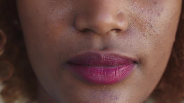 Nahaufnahme, Lippen einer schwarzen Frau mit rosa Lippenstift — Stockvideo