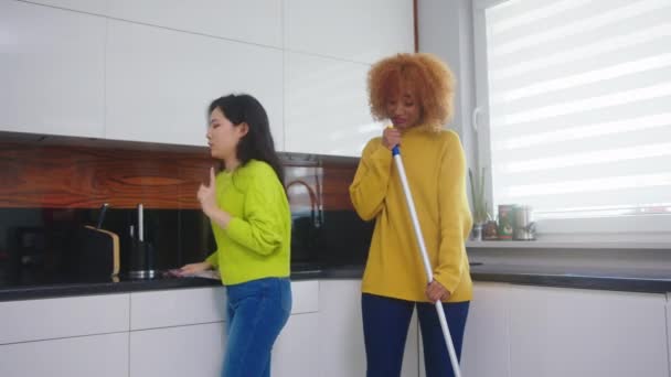 Giovani donne felici, africane americane e asiatiche, che si divertono mentre puliscono la cucina. Rapporto sano e concetto di famiglia multirazziale — Video Stock
