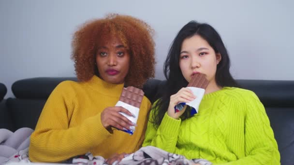 Duas mulheres lésbicas casal assistindo televisão e comer chocolates — Vídeo de Stock