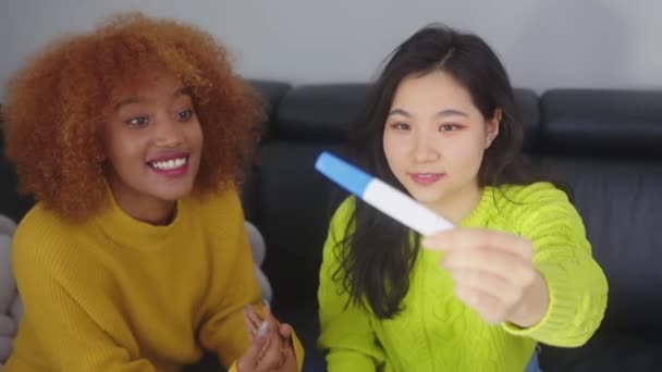 Heureuses deux jeunes femmes qui regardent un test de grossesse positif. Meilleur ami soutenant la future mère — Video