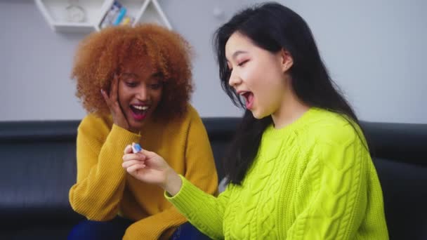 Szczęśliwe dwie młode kobiety najlepsze przyjaciółki patrząc na pozytywny test ciążowy — Wideo stockowe