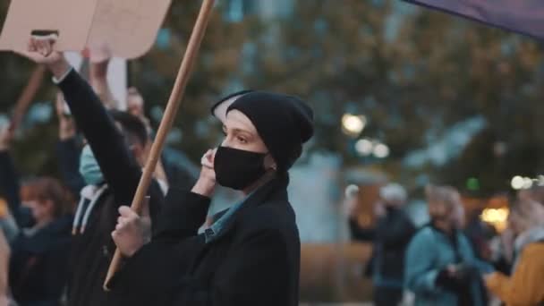 戴面具的女人拿着扩音器和彩虹旗.反对相互指责的示威 — 图库视频影像