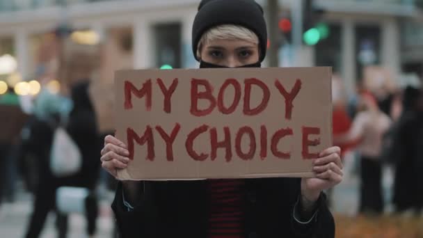 女人拿着标志我的身体，我的选择。抗议加强堕胎法。全国妇女罢工。戴防护口罩对抗COVID-19型结肠病毒. — 图库视频影像