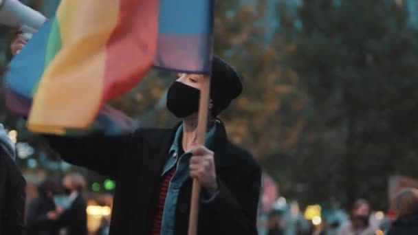戴面具的女人拿着扩音器和彩虹旗.反对相互指责的示威 — 图库视频影像