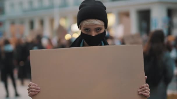 Протести та демонстрації. бунтівлива жінка з маскою для обличчя вражає — стокове відео
