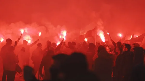 Varsóvia, Polônia 11.11.2020 - Dia da independência marche no aniversário de 102 anos em Varsóvia. Pessoas marchando na fumaça vermelha — Fotografia de Stock