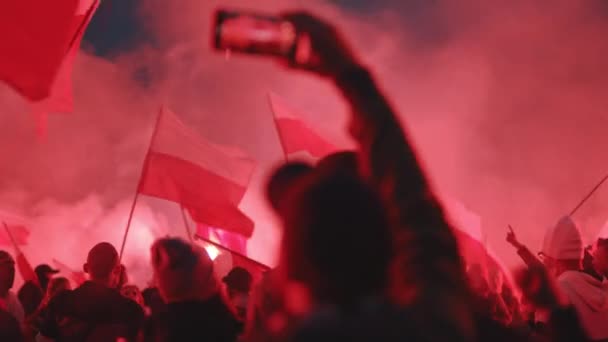 Warschau Polen 11.11.2020 - Deelnemers aan de onafhankelijkheidsmars branden rode fakkels op de rotonde van Dmowski in Warschau — Stockvideo