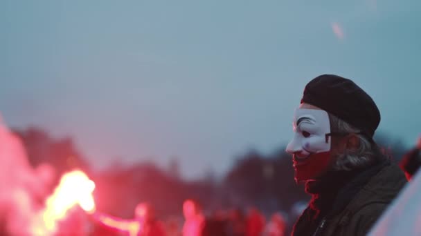 Varsovia, Polonia 11.11.2020 - 102º aniversario del Día de la Independencia de Polands. Hombre con máscara facial en colores glag pulido de pie en el gropu de la gente ardiendo bengalas rojas — Vídeos de Stock