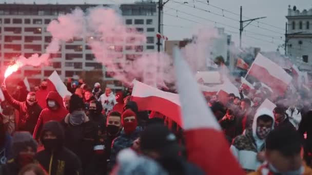 Warszawa 11.11.2020 - Marsz Dnia Niepodległości w 102. rocznicę powstania w Warszawie. Tłum ludzi maszerujących z polskimi flagami i czerwonymi flarami — Wideo stockowe