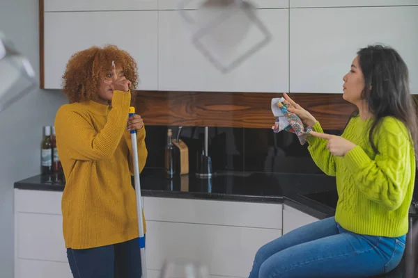 Twee jonge vrouwen die plezier hebben terwijl ze schoonmaken. Multiraciale vriendschap of relatie — Stockfoto