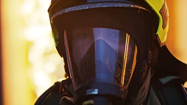Close up, retrato de bombeiro usando máscara de gás na frente da casa em chamas — Fotografia de Stock