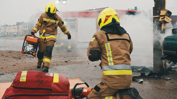 Dos bomberos en la escena del accidente de coche —  Fotos de Stock