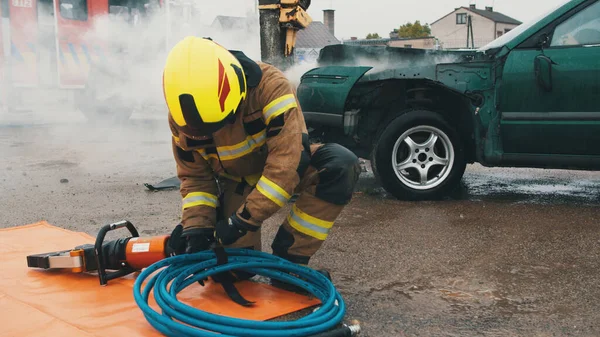 Пожежник, який готує шланг, прихований гідравлічний різак на місці аварії автомобіля — стокове фото