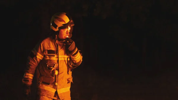 Bombeiro de uniforme completo na cena do acidente à noite — Fotografia de Stock