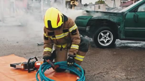 Firefighters preparing the hose wor hidraulic cutter on the car crash scene — Stock Video