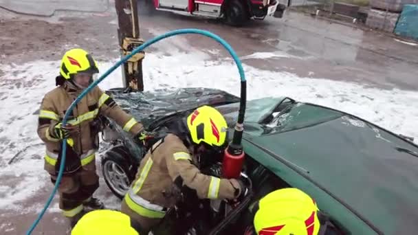 Пожарный разрезает двери автомобиля гидравлическим резаком. Автокатастрофа — стоковое видео