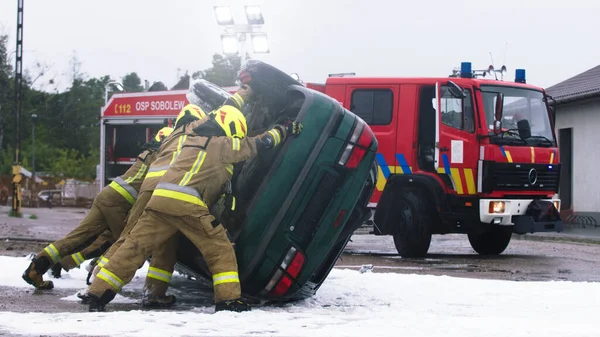 Feuerwehrleute drehen Auto nach Autounfall — Stockfoto