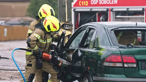 Bombeiro beraking vidro usando mandíbulas da vida para libertar vítima presa do carro — Fotografia de Stock