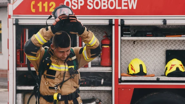 Bombero quitando casco de seguridad delante del camión de bomberos —  Fotos de Stock