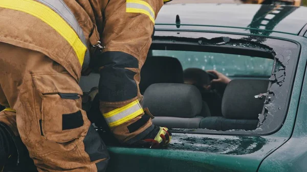 Bombero beraking vidrio en la ventana del coche sacar víctima atrapada del coche —  Fotos de Stock