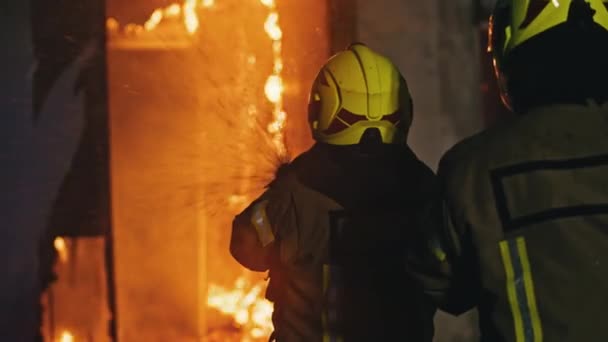 Tűzoltó oltsa el a tüzet a tömlővel. Égő házi tűzriadó — Stock videók