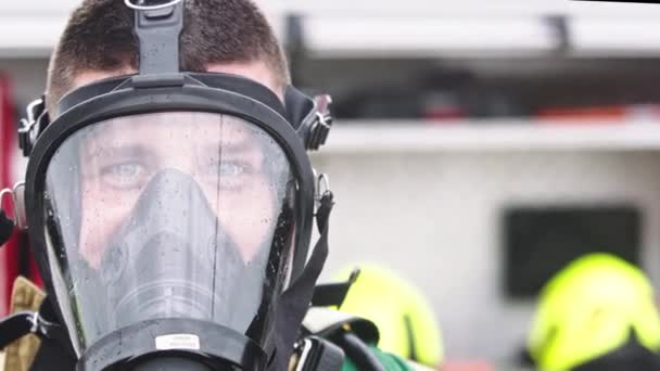 문을 닫고, 소방차 앞에 가스 마스크를 쓴 소방관의 초상화 — 비디오