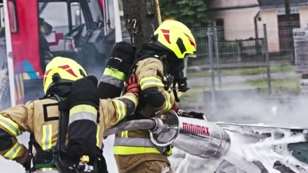 Warsaw, Poland, 06.05.2020 - Fire drill. Firefighters extinguish fire from the nurning car using the foam — Stock Video