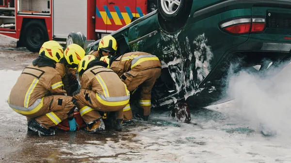 Пожежники рятують людину від автокатастрофи — стокове фото