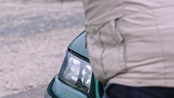 Un homme en colère casse une voiture avec un gros marteau. Concept de terreur et de vandalisme — Video