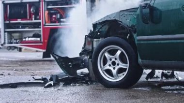 Arka planda itfaiye arabasından duman çıkıyor. Araba kazası.