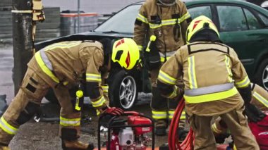 Varşova, Polonya 05.30.2020 İtfaiyeciler araba kazası sahnesinin hortum teli hidrolik kesicisini hazırlıyorlar.