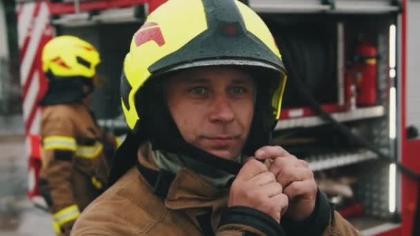 Retrato do bombeiro de uniforme completo e seu colegue na frente do caminhão de bombeiros — Vídeo de Stock