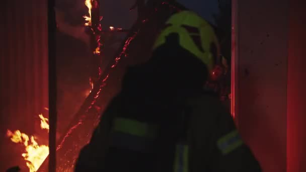 Brandweerman helpt om brand te blussen in brandend huis. — Stockvideo