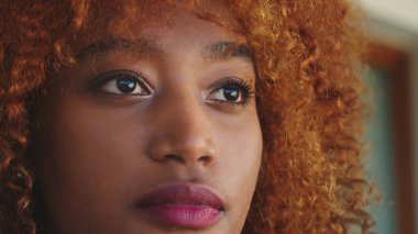Kıvırcık saçlı siyahi Afrikalı Amerikalı genç bir kadının portresi.