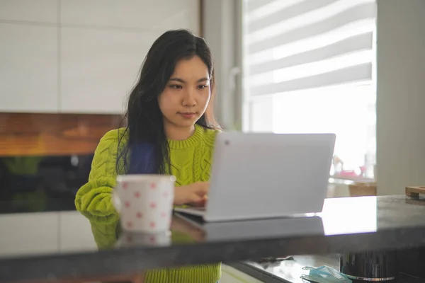 Mujer asiática joven usando el ordenador portátil en su balcón. Entretenimiento en el hogar o concepto de aprendizaje a distancia — Foto de Stock