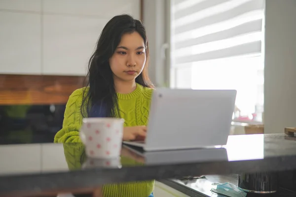 Mujer asiática joven usando el ordenador portátil en su balcón. Entretenimiento en el hogar o concepto de aprendizaje a distancia — Foto de Stock