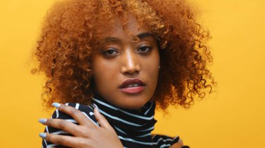 Güzel Afro-Amerikan siyah kadın yeni kıvırcık saç stilini gösteriyor.