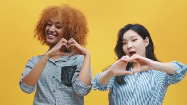 Concept d'amitié multiraciale. afro-américain noir et asiatique femme faire coeurs avec mains — Video