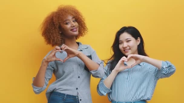Concept d'amitié ou de relation multiraciale. afro-américain noir et asiatique femme faire coeurs avec mains — Video