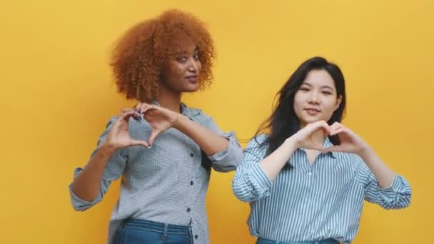 Concept de relation homosexuelle multiraciale. afro-américain noir et asiatique femme faire coeurs avec mains — Video
