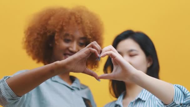 Concept de relation homosexuelle multiraciale. afro-américain noir et asiatique femme faire coeurs avec mains et loking à l 'autre — Video