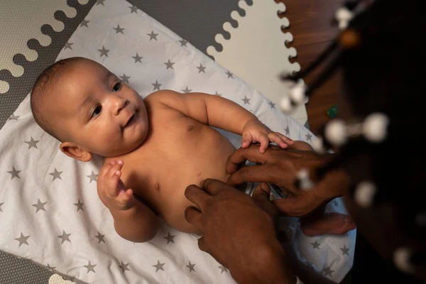 Paternidade e família multirracial. afetuoso jovem preto pai cócegas seu mulato bebê — Fotografia de Stock