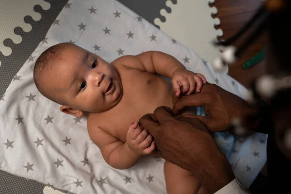 Fürsorglicher junger schwarzer Vater beim Windelwechseln. Vaterschaft und multirassische Familie — Stockfoto