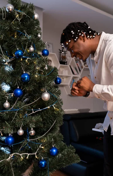 Hombre negro afroamericano joven decorando el árbol de Navidad — Foto de Stock